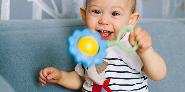 Baby with toy rattle