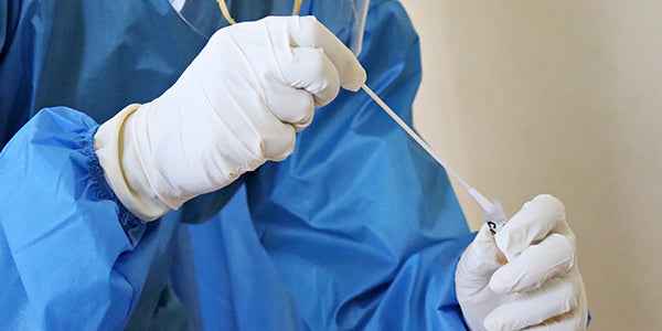 Nurse holding COVID testing swab