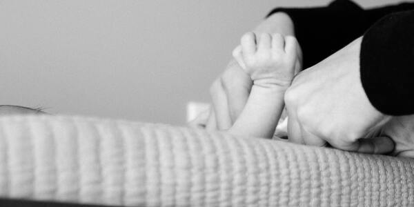 Black and white image of a woman changing a baby's diaper