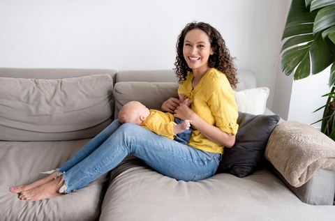 Erin Pasquet holding her newborn son wearing matching yellow top and blue jean outfits