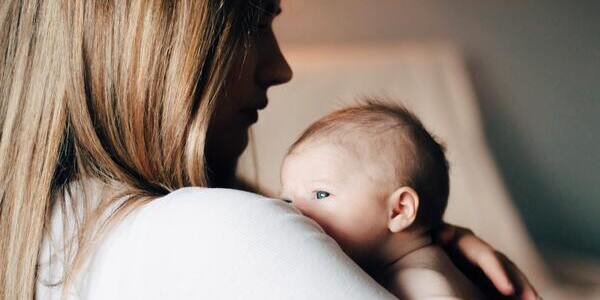 Mother holding baby looking towards them