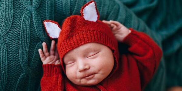 Sleeping baby with a red outfit on