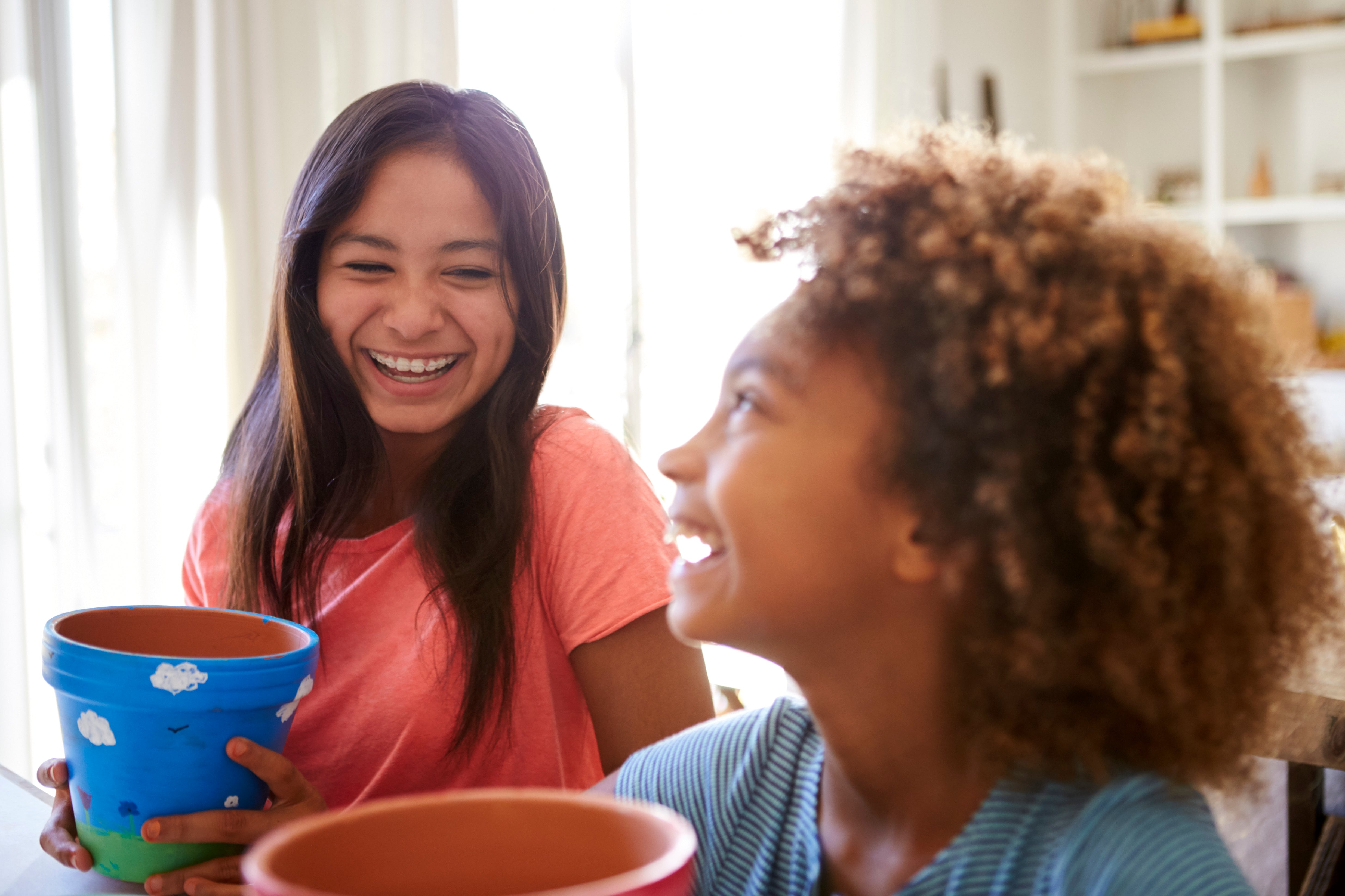 Laughing girls with painted pot