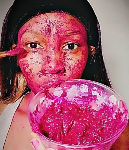 black woman applying red beetroot facial mask