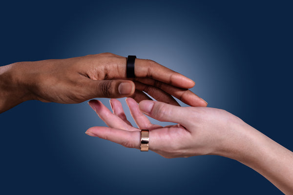 Hands wearing Ultrahuman Ring AIR in Black and Gold