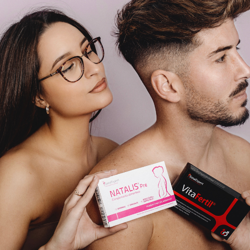 Eine Frau und ein Mann nebeneinander, die Frau hält eine Packung Natalis Pre, der Mann eine Packung VitaFerrin, vor einem hellvioletten Hintergrund.