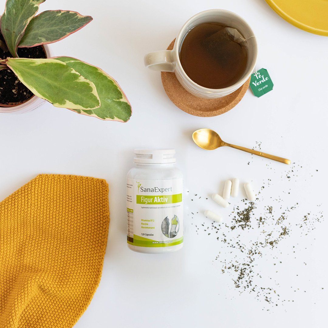 Gemütlicher Moment mit einer Tasse grünem Tee und SanaExpert Figur Aktiv Kapseln, ergänzt durch eine warme, gelbe Strickarbeit und grüne Pflanzen, ideal für eine kleine Auszeit.