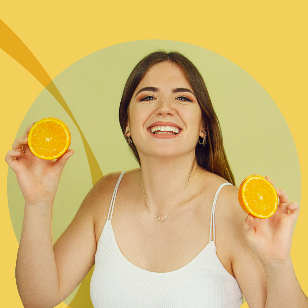 Strahlende junge Frau, die Orangenscheiben hält und lächelt, umgeben von einem warmen gelben Kreis, symbolisch für Frische und Vitamine.