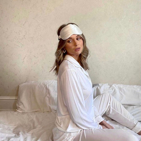 Girl in bed wearing ivory silk eye mask 