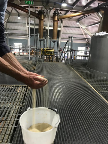 yeast falling from distillers hands into bucket