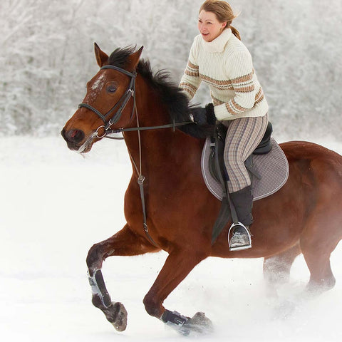 Woman on galloping horse in the snow