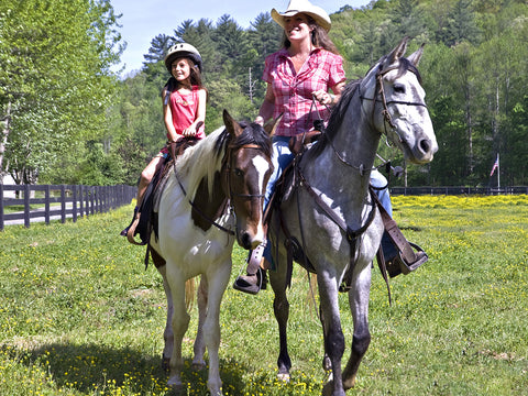 woman and young girl riding a horses