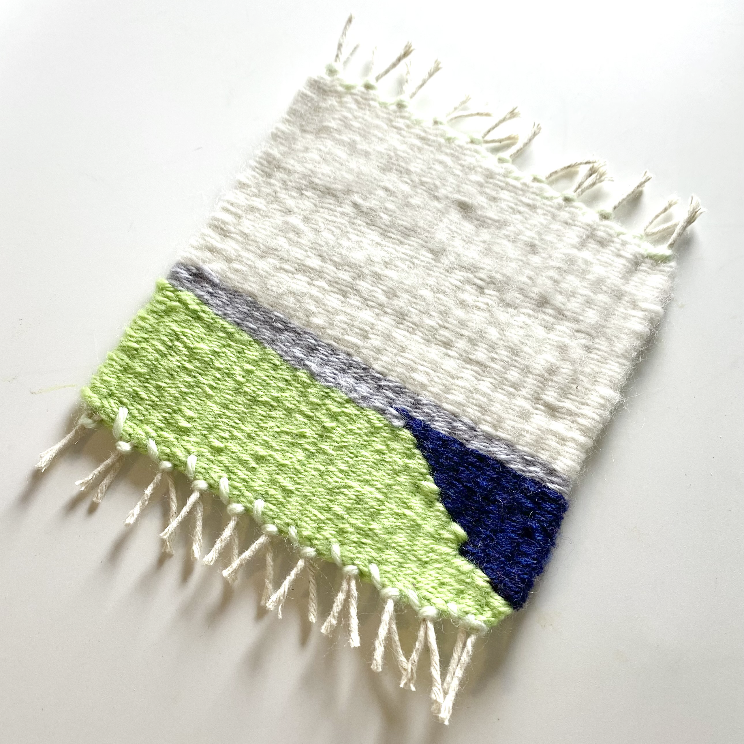 Green, blue, grey, cream geometric hand woven coaster with fringe