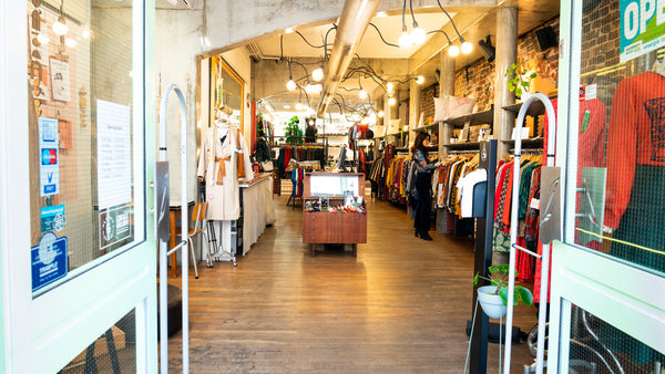 Interieur van de winkel, vanuit buiten gezien. De deuren staan wijd open