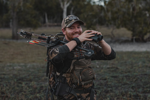 Bowhunter smiling and glassing with binoculars