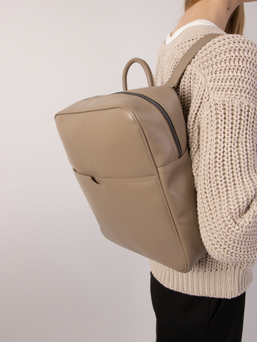 A minimalistic urban backpack in beige made of a vegan leather alternative.