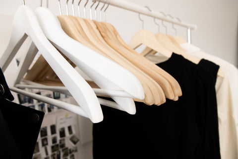A clothes rail on which hang several hangers and a few clothes. An example of a minimalist, capsule wardrobe
