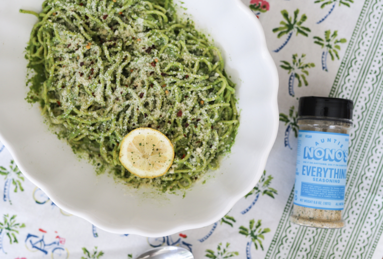 Auntie Nono's and Big Charlie's Arugula Pesto Pasta in a serving dish with a bottle of everything seasoning beside it