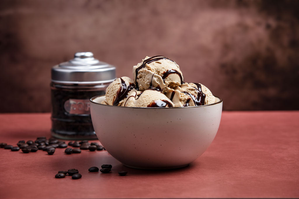 Bowl of coffee ice cream with chocolate sauce drizzled on top.