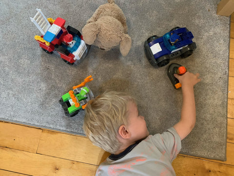Child playing with toy cars on the ground