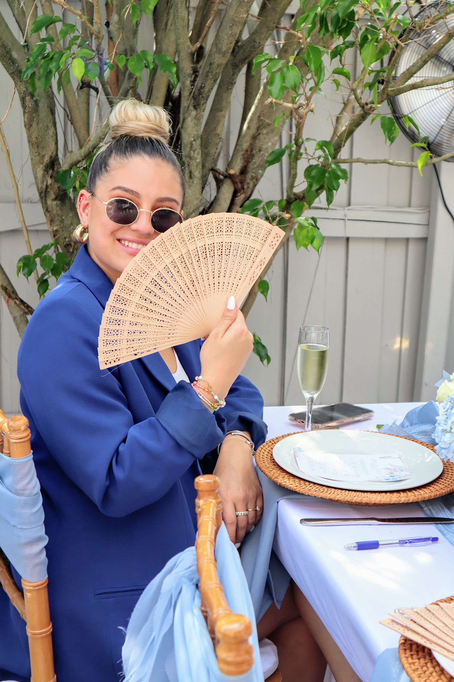 family member holding handheld fan outdoors at teddy bear baby shower