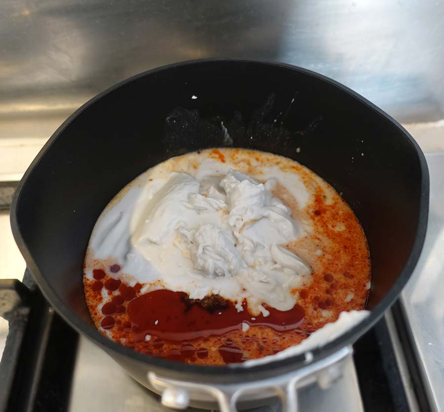 Heat curry paste and coconut milk together in pan