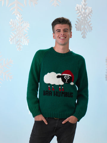 Image of knitting pattern cover showing a man wearing a Christmas jumper with a sheep on the front wearing a Santa hat and saying Baa Humbug