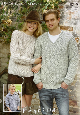 Image of cover of Sirdar knitting pattern 9219 featuring a selection of Aran sweaters modelled by a woman (round neck), man (v neck) and child (collar) all hand knitted in a neutral Aran yarn