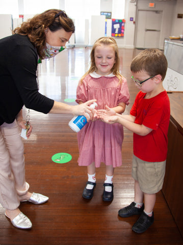 school children using h2one hand sanitizer