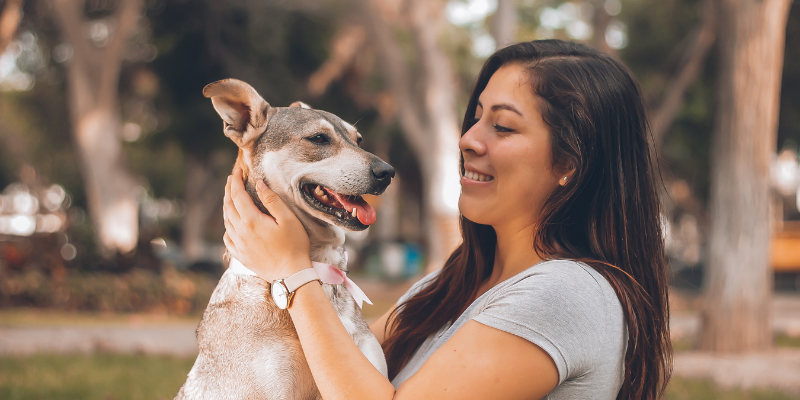 Happy woman holding healthy vegan dog