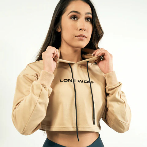 Brunette holding the hood of a tan cropped hoodie from Lone Wolf