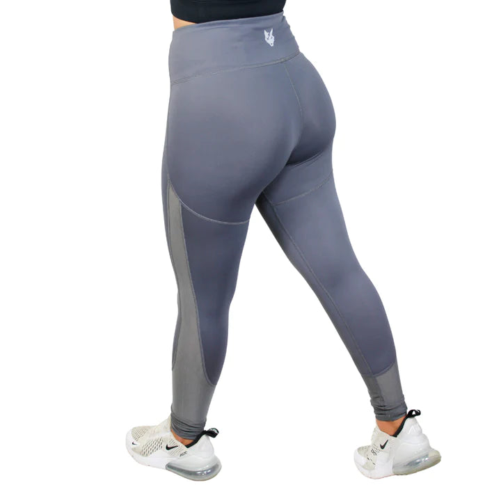 Women’s legs wearing gray workout leggings and white Nike shoes