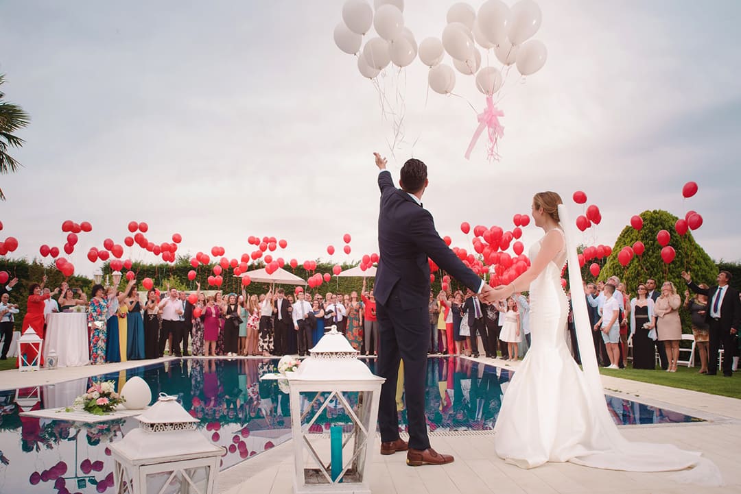 Bride and groom releasing balloons outside
