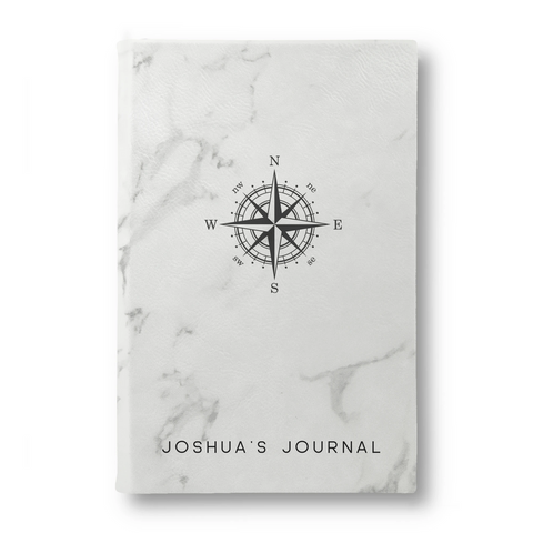 A white marble journal with a compass and the words Joshua’s Journal