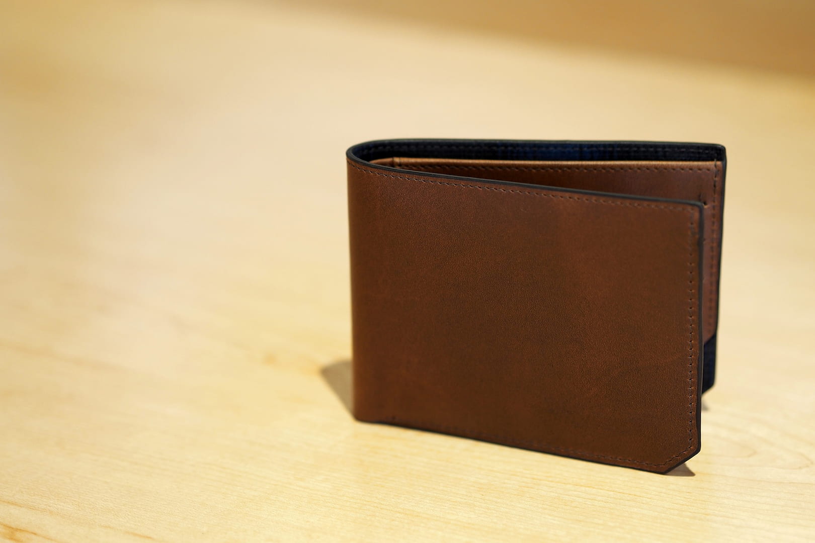 Leather wallet standing on a wooden surface
