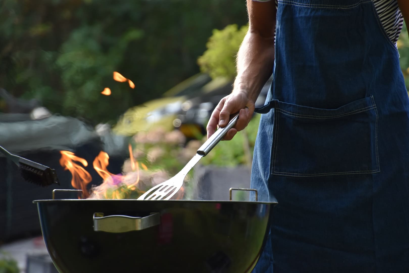 Man in apron grilling on barbecue