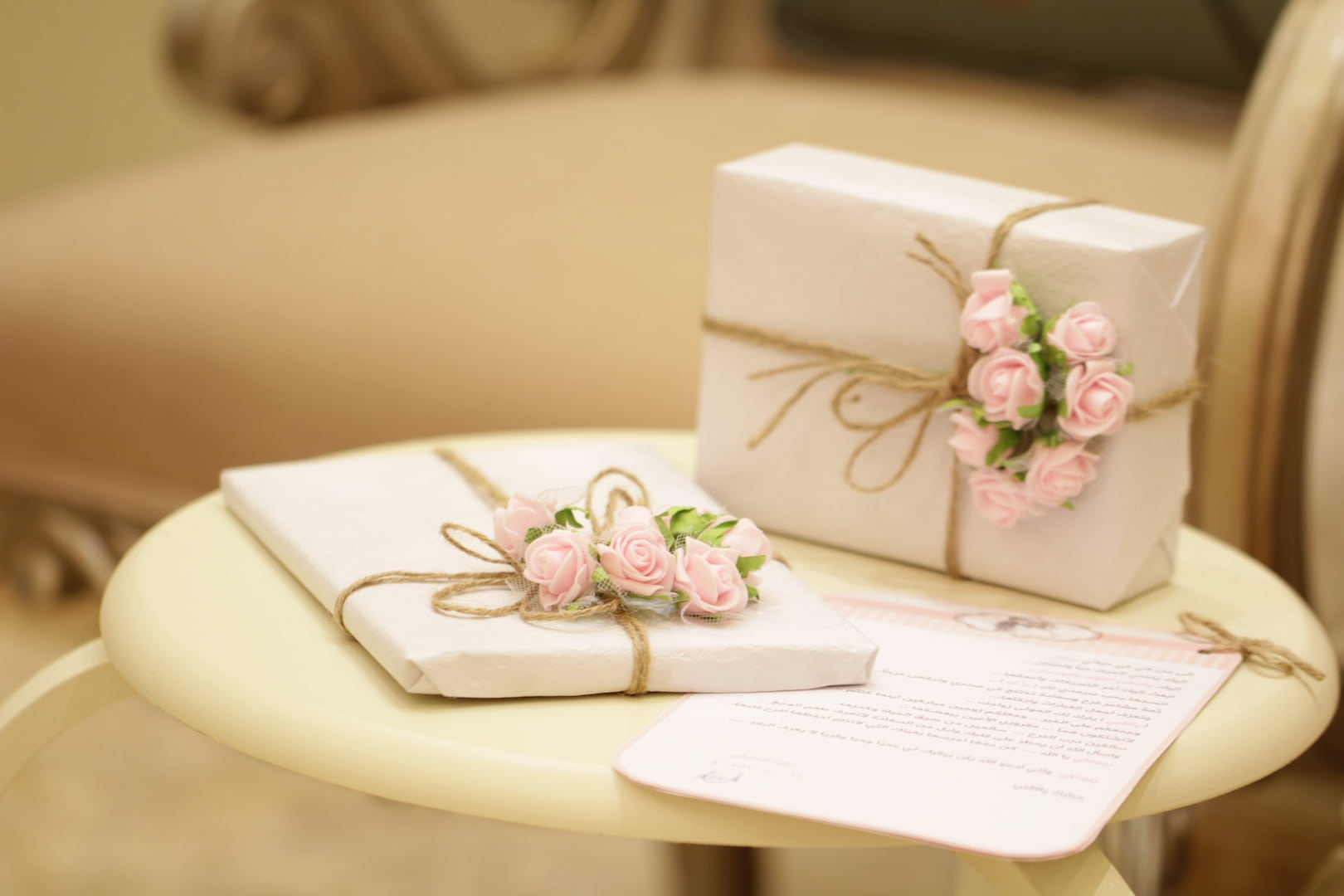 Two wrapped gifts with roses on a table