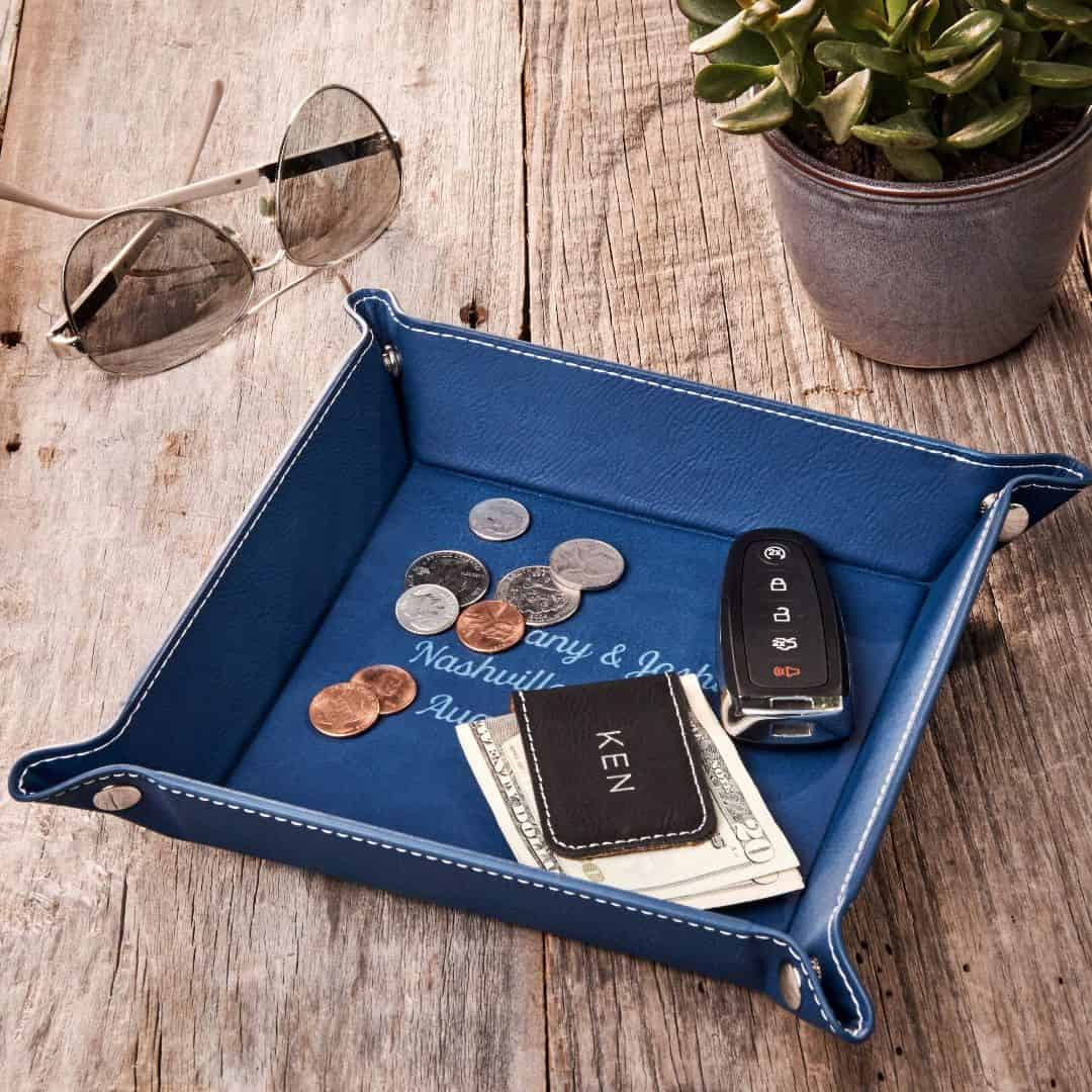 A valet tray holding coins, cash, and a car key remote