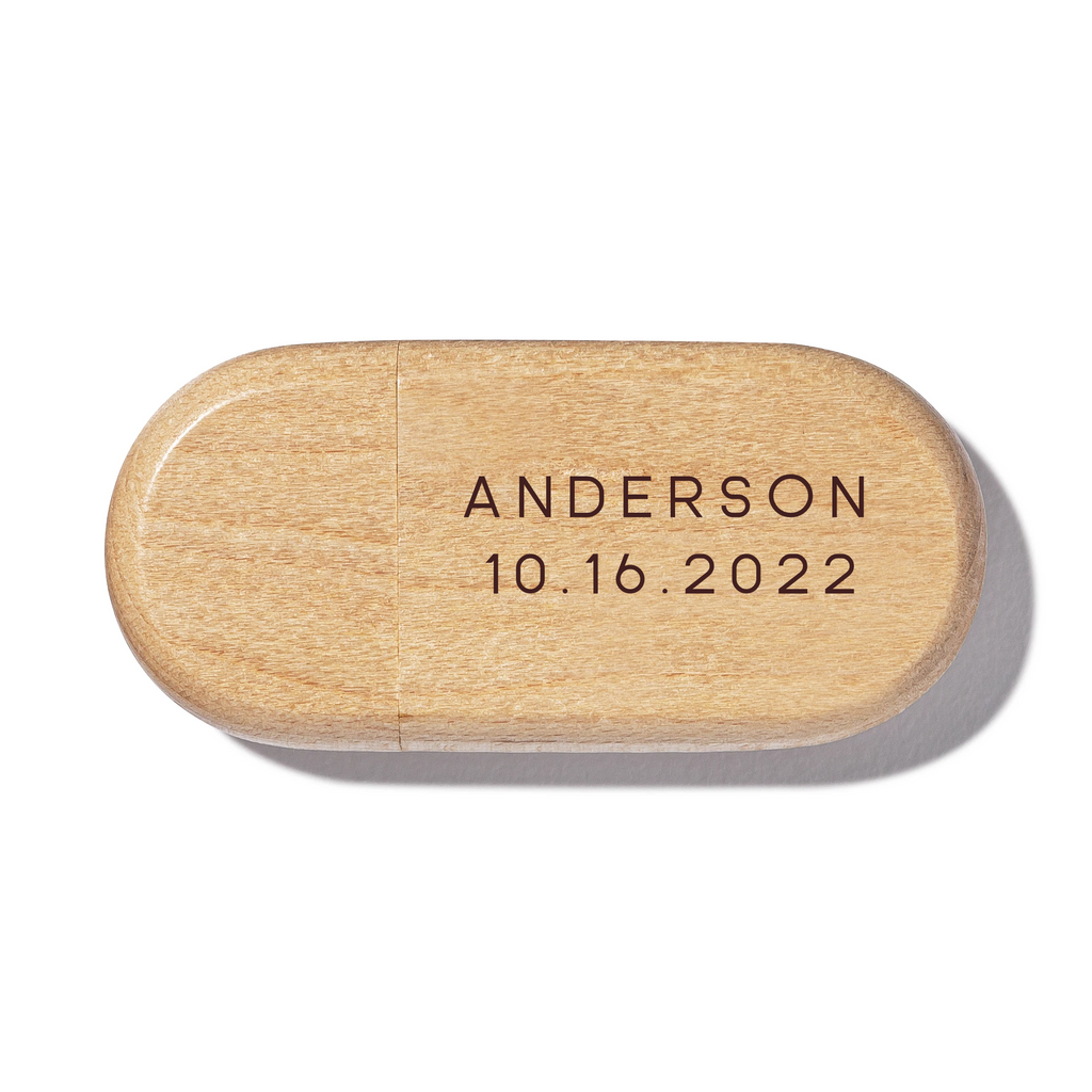 A wooden USB drive with engraved name and date