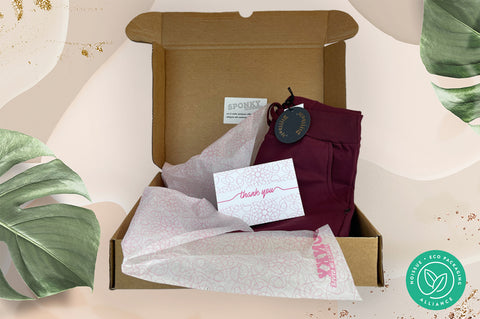 foto packaging sostenibile con scatola di cartone, carta velina ecologica e cartolina di ringraziamento