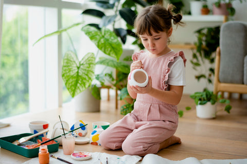 Girl painting a pot