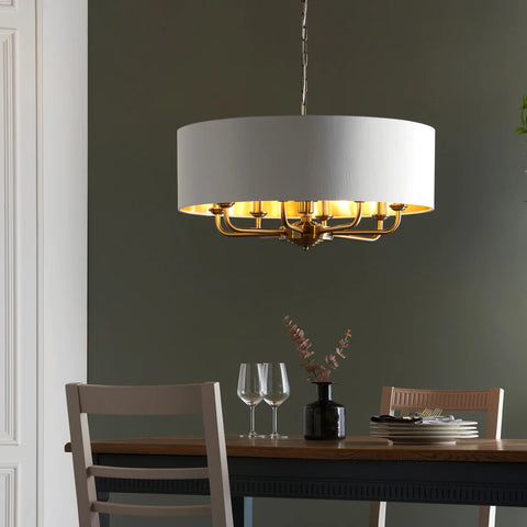 white round pendant light with 8 bulbs suspended over a dining table
