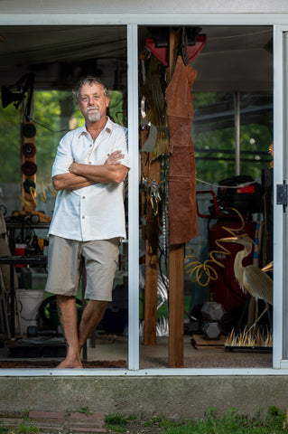 Mike, leaning up against the doorway of his workshop