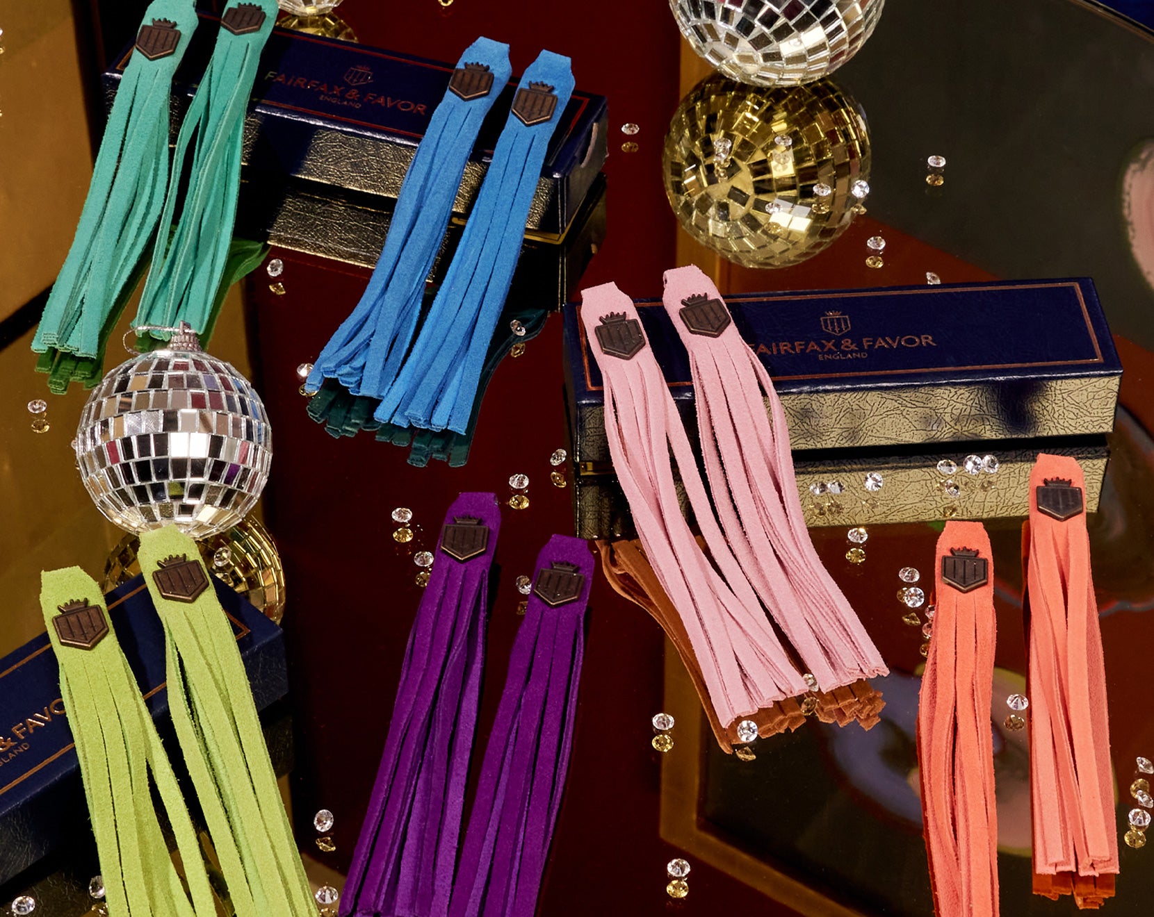A variety of boot tassels on a table with diamonds and festive boxes - perfect for gifting muom