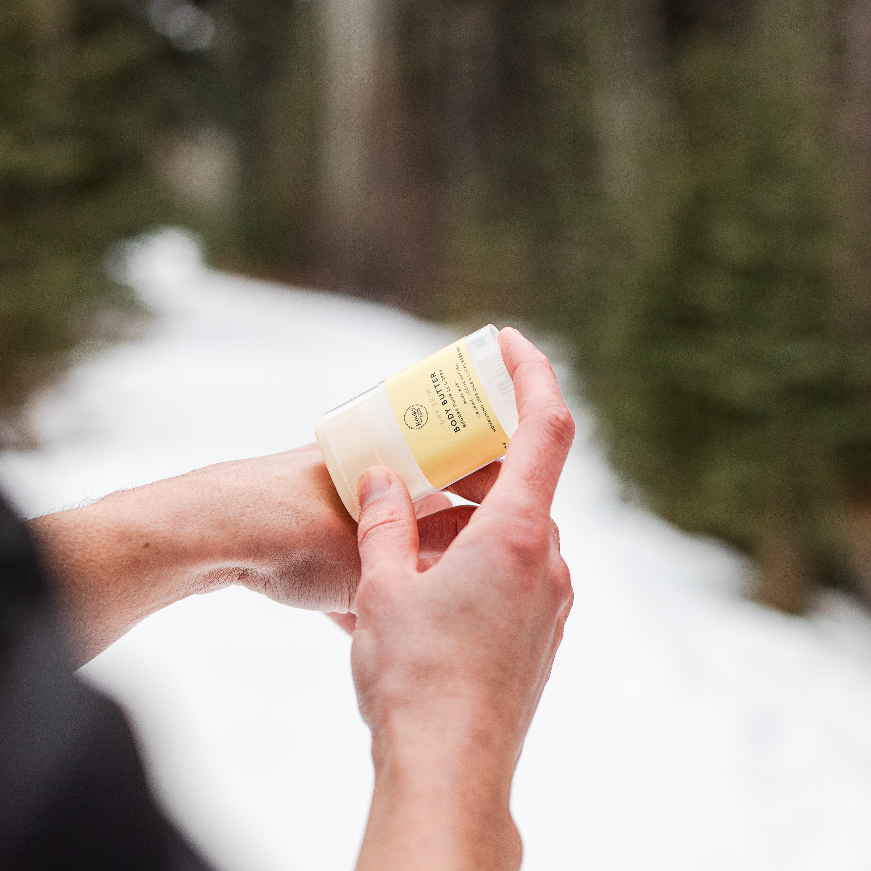 Person applying natural unscented body butter to their hands. 