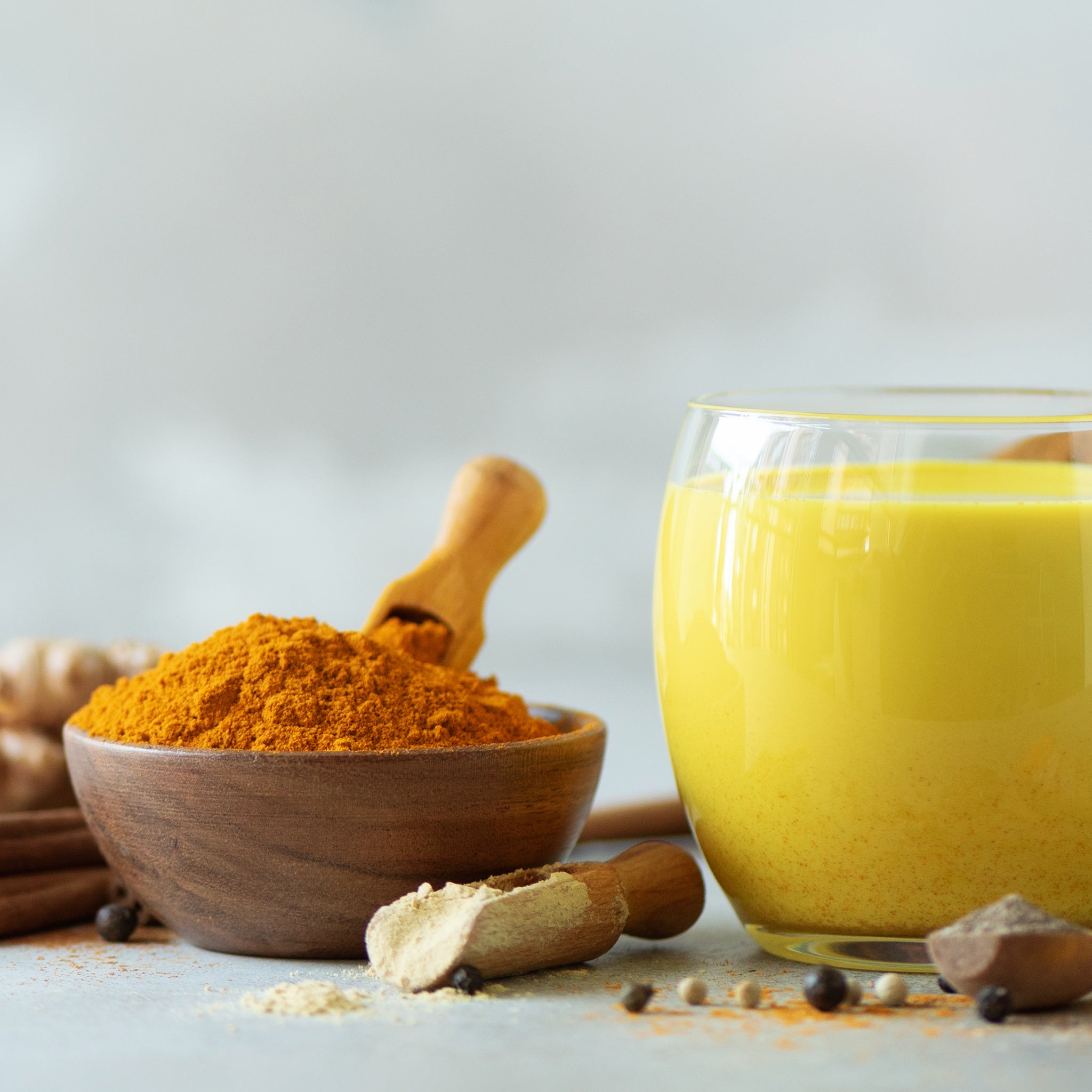 turmeric latte surrounded by raw ingredients 