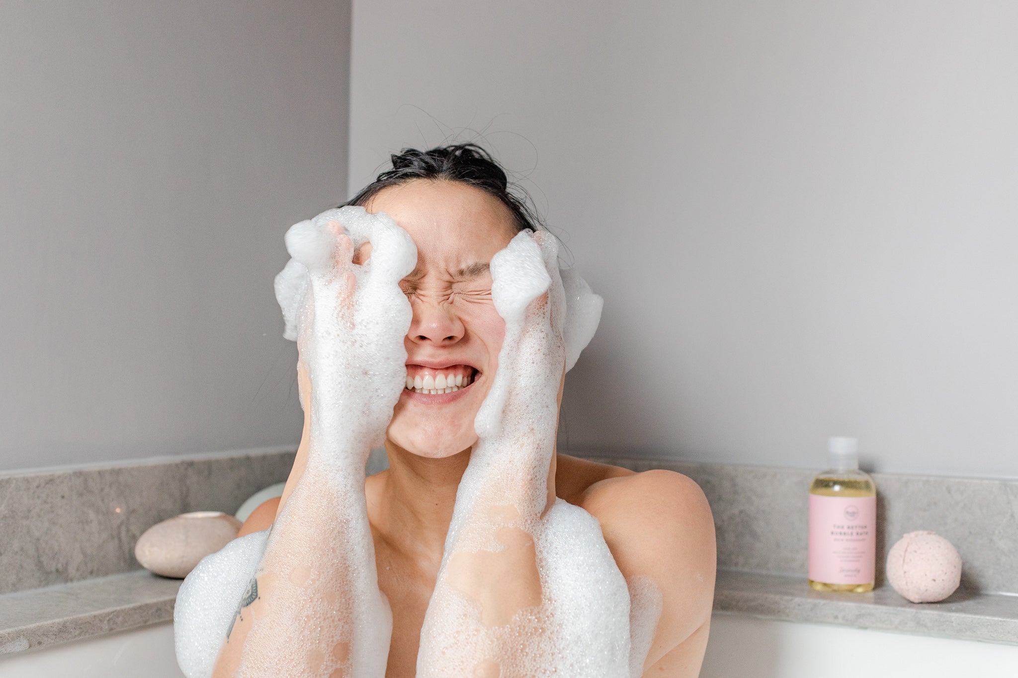 Image of woman and suds on her face with natural bubble bath 
