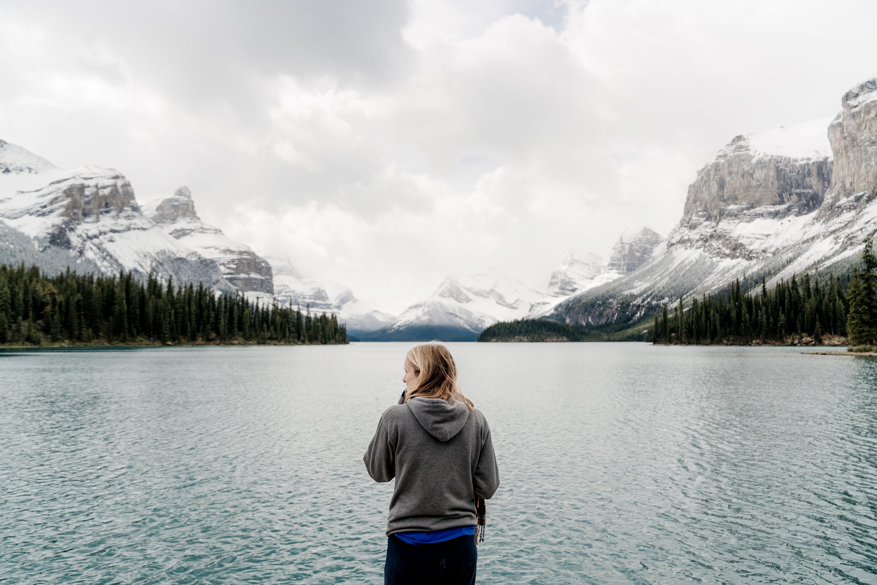 image of woman looking at lake and mountains. 