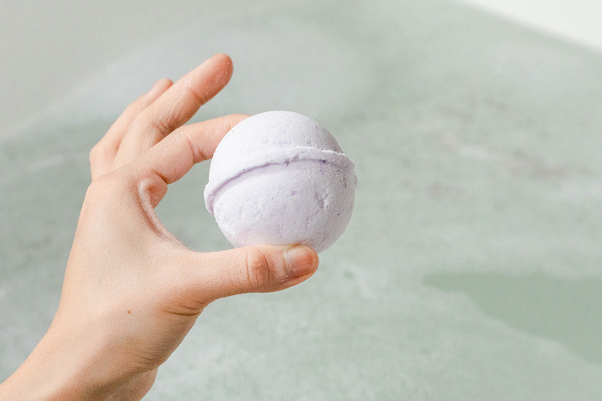 Image of natural bath bomb about to drop in bath.