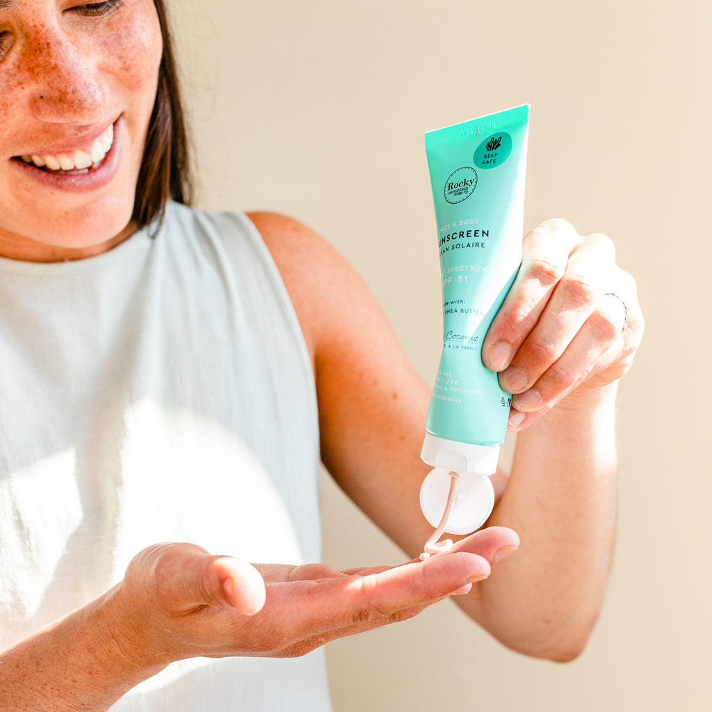 Woman squeezing natural sunscreen into her palm. 